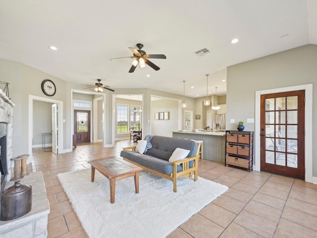 living area with light tile patterned floors, recessed lighting, visible vents, a fireplace with raised hearth, and baseboards