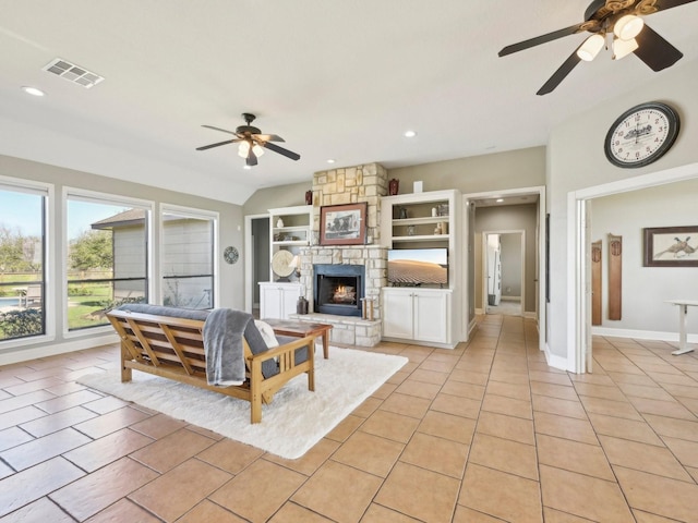 living area featuring light tile patterned floors, visible vents, lofted ceiling, a stone fireplace, and recessed lighting