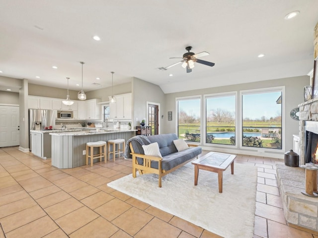 living room with light tile patterned floors, recessed lighting, a ceiling fan, vaulted ceiling, and a lit fireplace