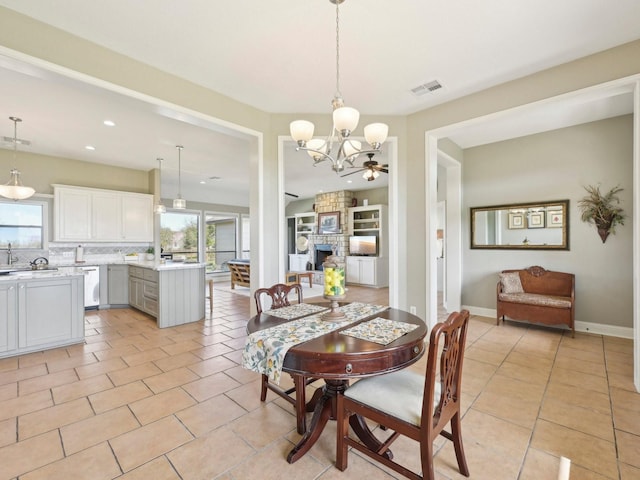 dining room featuring baseboards, a fireplace, visible vents, and light tile patterned flooring