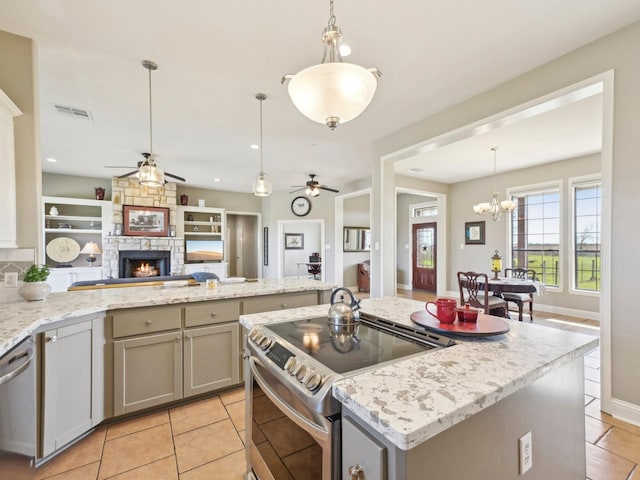 kitchen with visible vents, open floor plan, gray cabinets, stainless steel appliances, and a stone fireplace