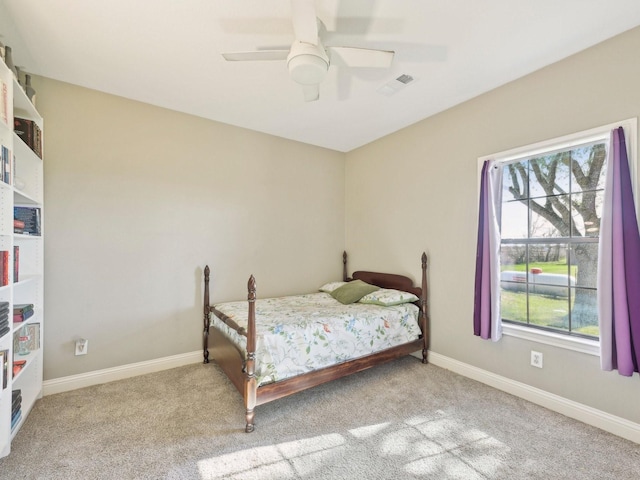 carpeted bedroom featuring baseboards, visible vents, and ceiling fan