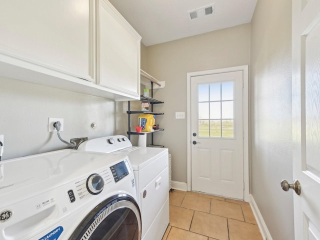 washroom featuring light tile patterned floors, visible vents, baseboards, cabinet space, and washing machine and clothes dryer