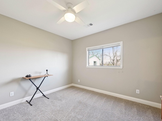 spare room featuring a ceiling fan, visible vents, light carpet, and baseboards