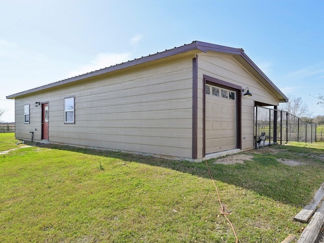 exterior space featuring driveway, fence, metal roof, and a yard