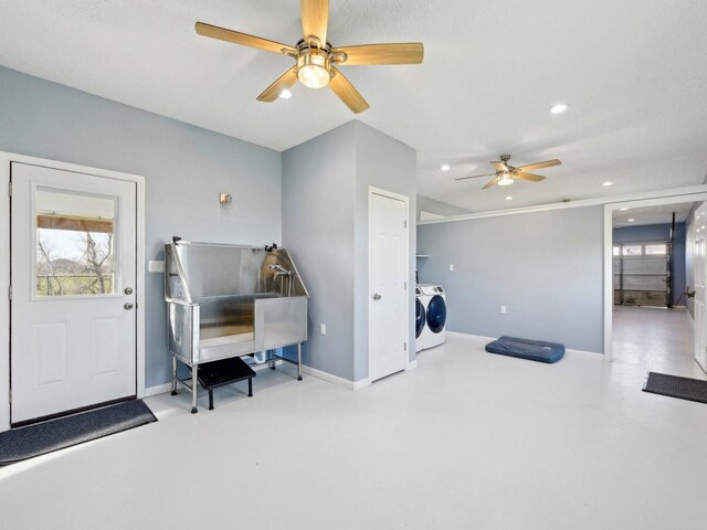 misc room with finished concrete floors, recessed lighting, washer and clothes dryer, and baseboards