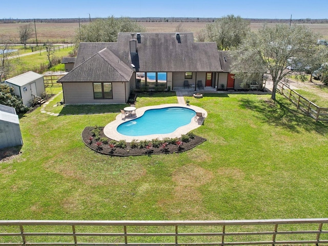 view of pool featuring a yard, a rural view, and fence