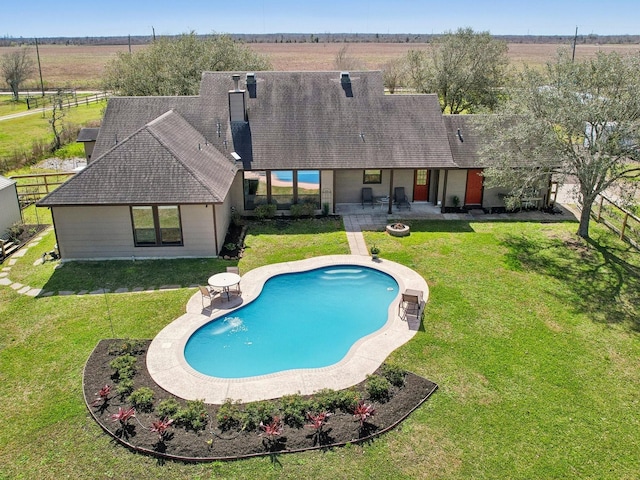 outdoor pool featuring a patio, fence, and a lawn