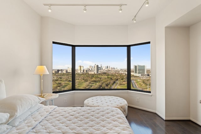 bedroom featuring a view of city, baseboards, and hardwood / wood-style floors