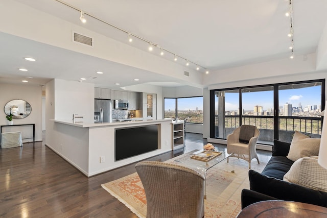 living area with a city view, recessed lighting, dark wood finished floors, and visible vents