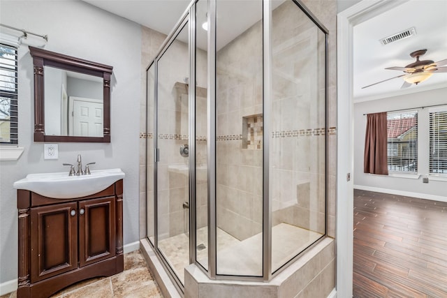 bathroom featuring visible vents, a shower stall, baseboards, ceiling fan, and vanity