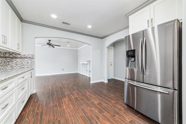 kitchen featuring tasteful backsplash, visible vents, dark wood finished floors, stainless steel refrigerator with ice dispenser, and arched walkways