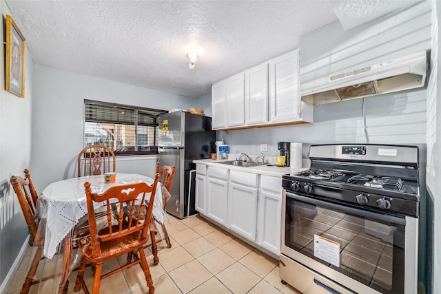 kitchen featuring light countertops, light tile patterned floors, appliances with stainless steel finishes, white cabinets, and a sink