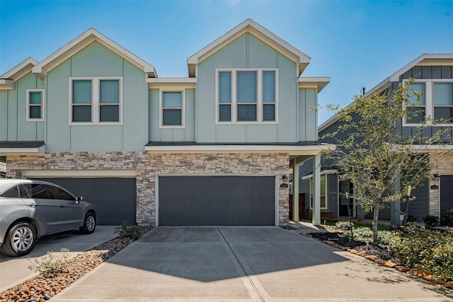 view of property featuring stone siding, board and batten siding, concrete driveway, and a garage