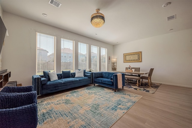 living room featuring wood finished floors, visible vents, and baseboards