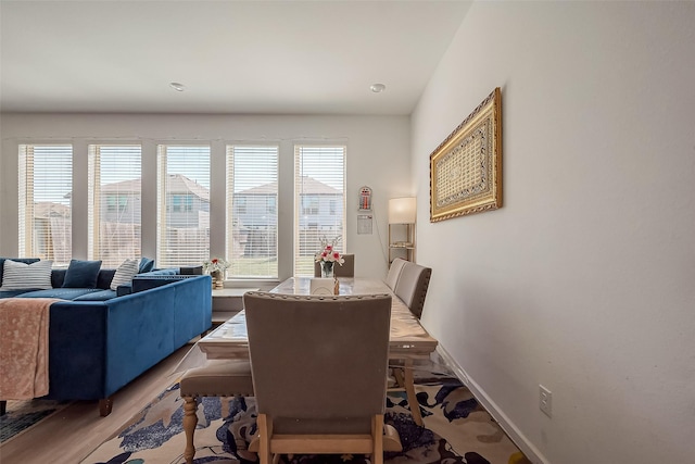 dining room featuring a healthy amount of sunlight, baseboards, and wood finished floors