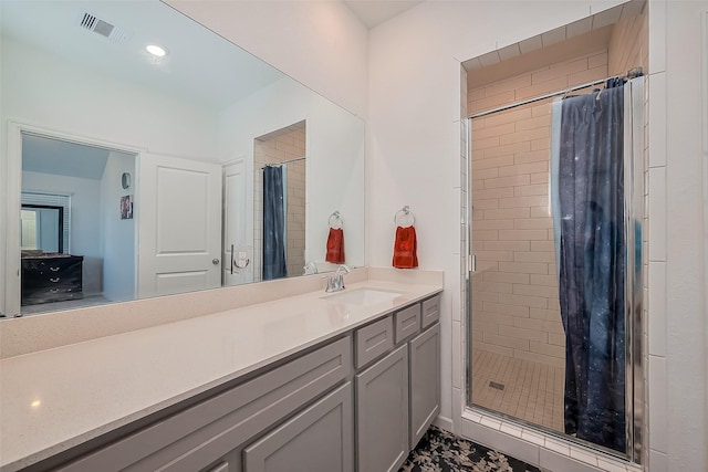 bathroom with vanity, a shower stall, and visible vents