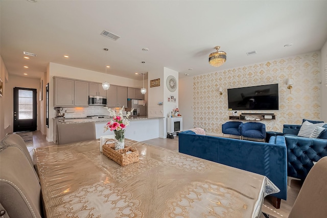 dining area with visible vents and wallpapered walls