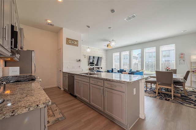 kitchen with visible vents, gray cabinets, wood finished floors, and stainless steel dishwasher