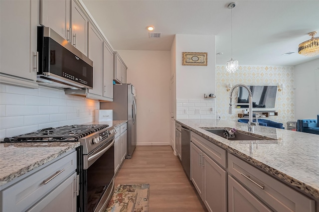 kitchen featuring gray cabinets, visible vents, appliances with stainless steel finishes, and a sink