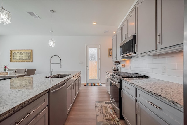 kitchen featuring a sink, gray cabinets, visible vents, and stainless steel appliances