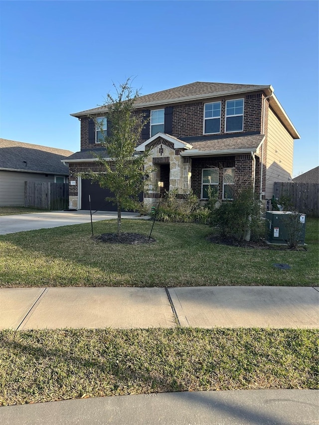 view of front of house featuring driveway, brick siding, an attached garage, fence, and a front yard