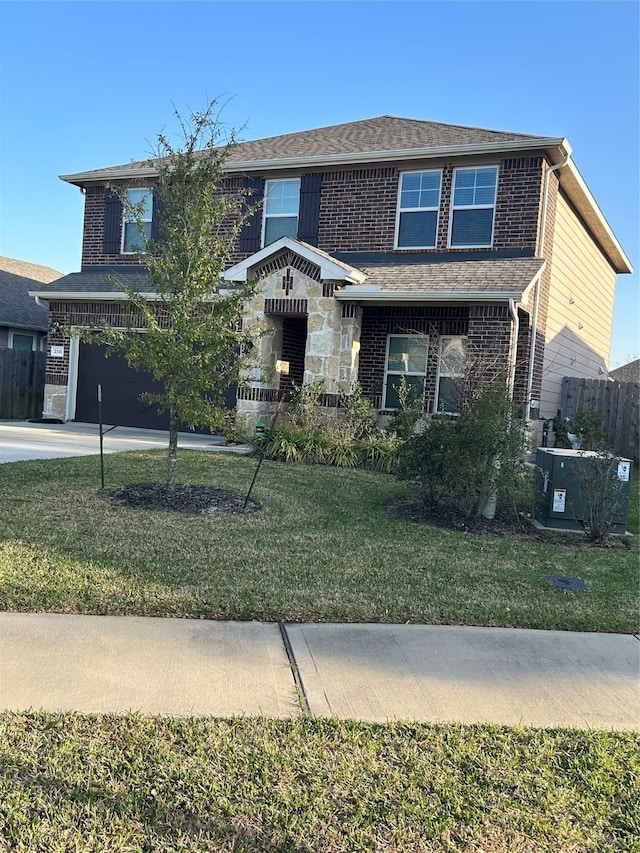 traditional-style home featuring brick siding, central air condition unit, a front yard, a garage, and driveway