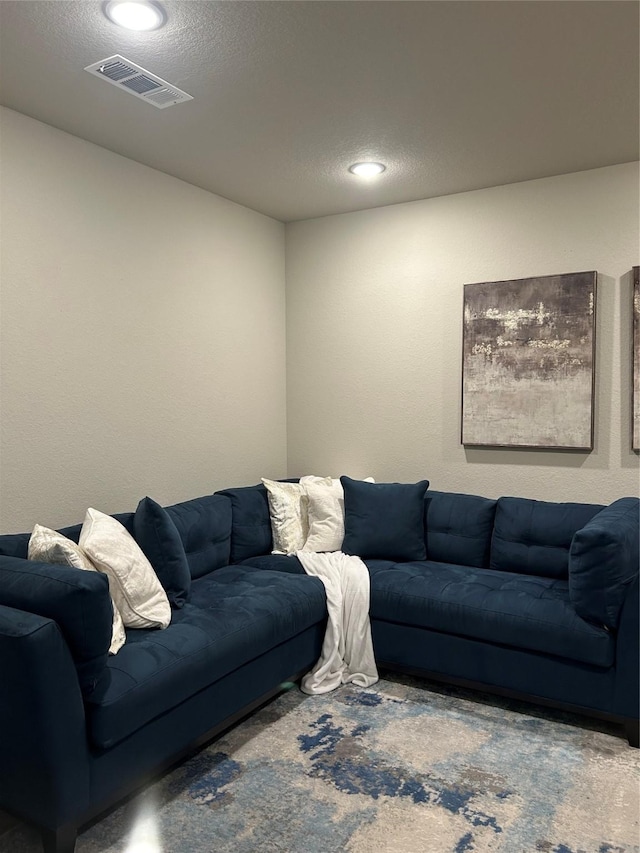 living area with a textured ceiling and visible vents