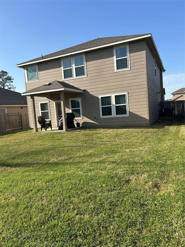 back of property with a lawn, a patio area, and fence