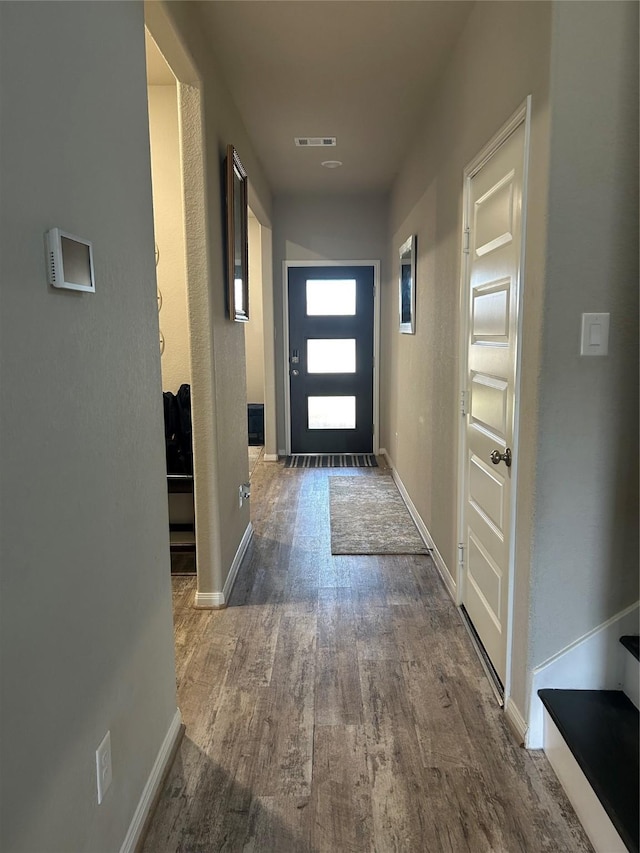 entryway featuring visible vents, baseboards, and wood finished floors