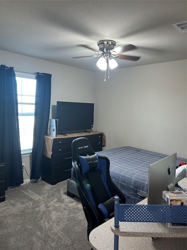 carpeted bedroom featuring visible vents, ceiling fan, and a textured ceiling