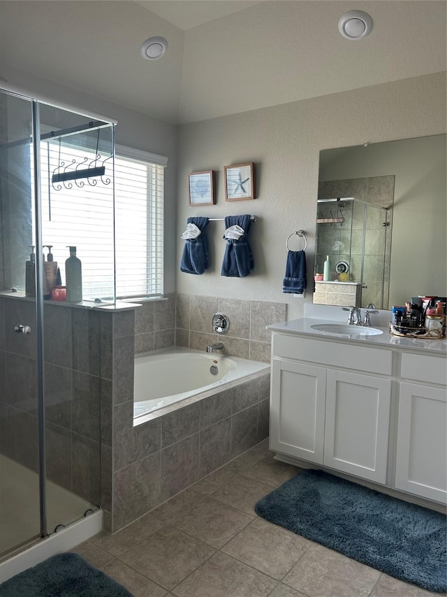 full bathroom featuring a stall shower, tile patterned flooring, a garden tub, and vanity