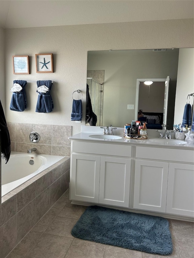 ensuite bathroom featuring double vanity, ensuite bath, a sink, and a shower stall