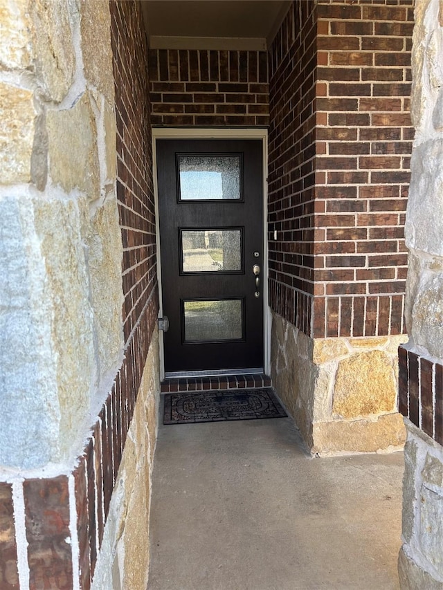 doorway to property with brick siding