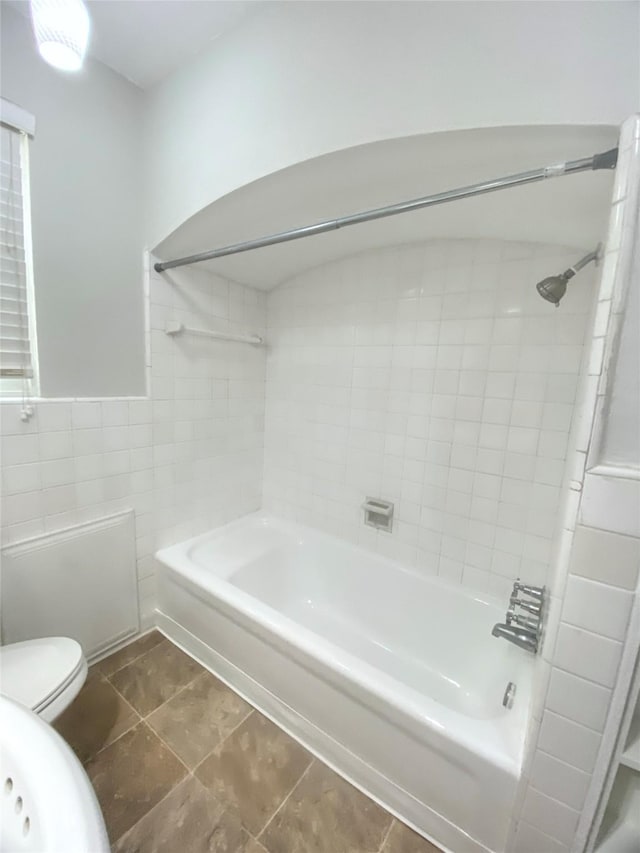 bathroom featuring toilet, shower / tub combination, tile walls, and tile patterned floors