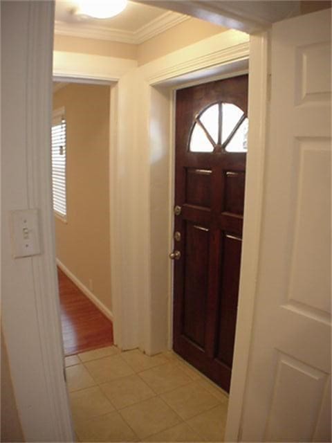 entrance foyer with light tile patterned floors, baseboards, and crown molding