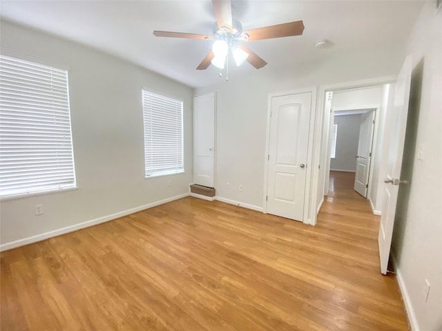 unfurnished bedroom featuring light wood-style floors, ceiling fan, and baseboards