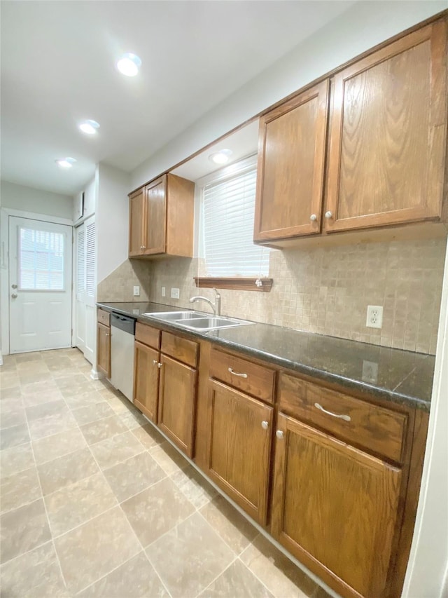 kitchen featuring tasteful backsplash, dishwasher, brown cabinets, a sink, and recessed lighting