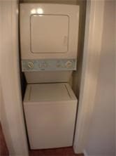 laundry room with stacked washer and dryer and laundry area