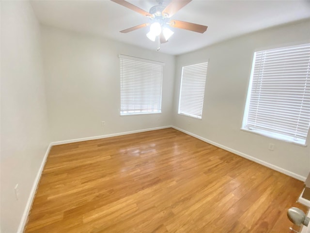 unfurnished room with light wood-style floors, baseboards, and a ceiling fan