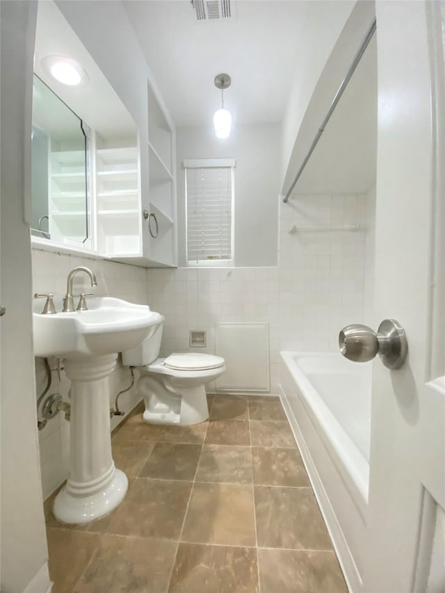 bathroom with tile walls and toilet