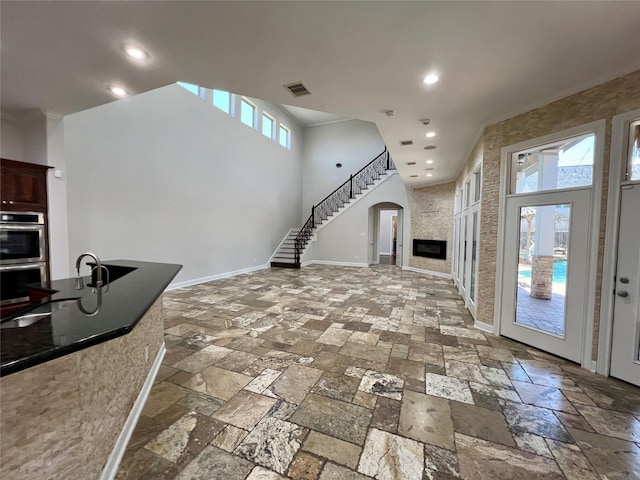 living room with a wealth of natural light, baseboards, stone tile floors, and recessed lighting