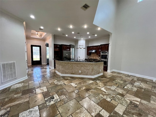 kitchen with visible vents, dark countertops, refrigerator with ice dispenser, and stone tile flooring