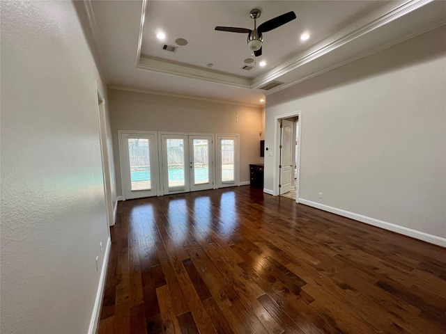 unfurnished living room featuring dark wood-style floors, visible vents, baseboards, ornamental molding, and a raised ceiling