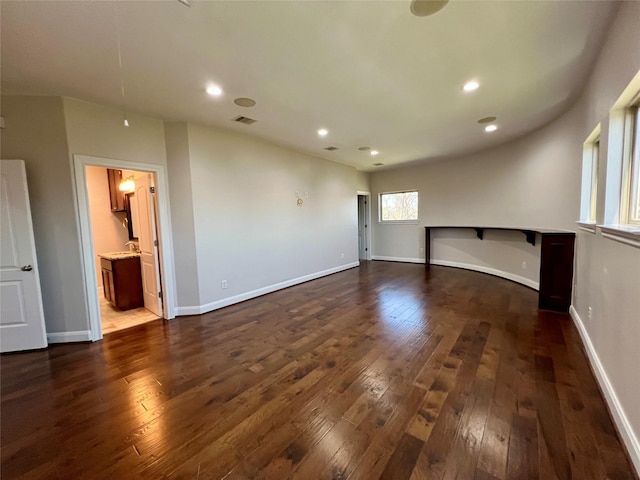 spare room with dark wood-style floors, visible vents, and baseboards