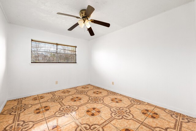 empty room featuring light tile patterned flooring, ceiling fan, a textured ceiling, and baseboards