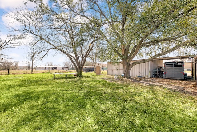 view of yard with an outbuilding, fence, and a pole building