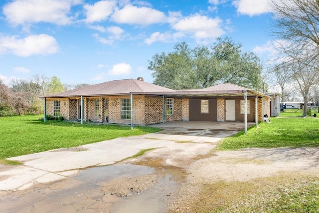 single story home featuring brick siding, concrete driveway, and a front yard