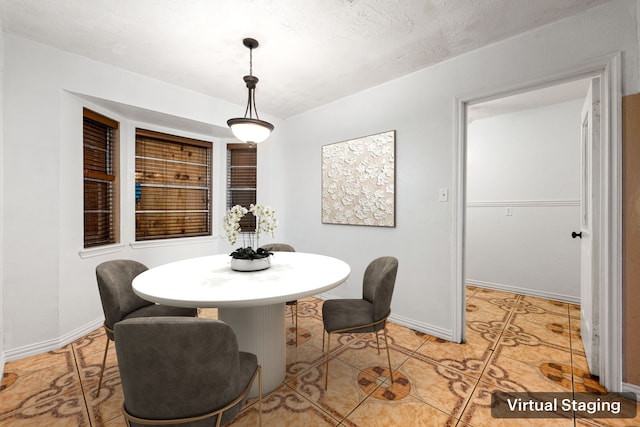 dining space with baseboards and a textured ceiling