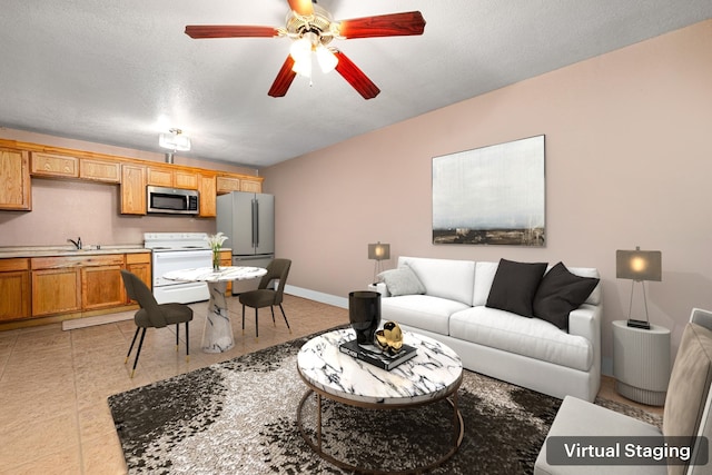 living area with baseboards, a textured ceiling, light tile patterned flooring, and a ceiling fan